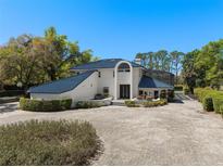 Stunning home featuring a blue tile roof and a meticulously landscaped front yard with an expansive brick driveway at 3326 Butler Bay N Dr, Windermere, FL 34786