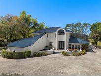 Stunning two-story home featuring a blue tile roof and lush landscaping at 3326 Butler Bay N Dr, Windermere, FL 34786