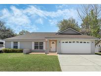 Charming single-story home featuring a well-manicured lawn and a two-car garage at 36 Se Almond Dr, Ocala, FL 34472