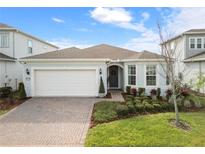Charming home featuring a well-manicured lawn, lush landscaping, and a paved driveway at 13916 Destin Beach Ln, Orlando, FL 32827