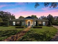 Charming brick home with manicured lawn, brick pathway, and lush landscaping, creating inviting curb appeal at 1600 Barcelona Way, Winter Park, FL 32789