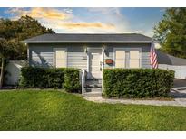 Charming single-story home with gray siding, manicured hedges, and a well-maintained lawn at 211 E Muriel St, Orlando, FL 32806