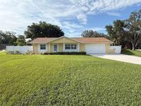 Charming single-story home with a well-manicured lawn, white picket fence, and attached two-car garage at 333 Crystal Cir, Oviedo, FL 32765