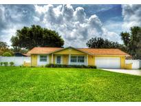 Charming single-story home featuring a lush green lawn and a welcoming yellow exterior at 333 Crystal Cir, Oviedo, FL 32765