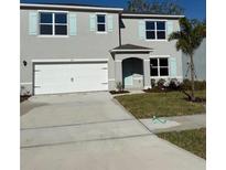 Charming two-story home with blue shutters, a two-car garage, and a well-maintained front yard at 512 Coronado Cove Rd, New Smyrna Beach, FL 32168