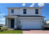 Two-story home featuring brick accents, an attached two-car garage, and a covered front entry at 7020 Rolling Leaf Rd, Groveland, FL 34736
