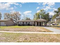 Charming single-story home with carport and spacious front yard on a sunny day at 7906 Arabian Pl, Orlando, FL 32818