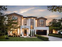 Stunning two-story home featuring a modern design with a brick and stucco exterior, manicured lawn, and professional landscaping at 1402 Stetson St, Orlando, FL 32804