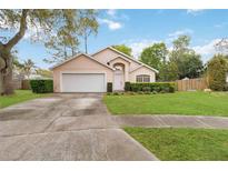 Charming single-story home featuring a well-maintained lawn, mature trees, and a two-car garage at 14026 Eckard Ct, Orlando, FL 32826