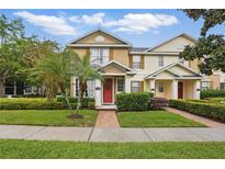 Charming two-story townhome with a brick walkway and a beautifully landscaped front yard at 14467 Prunningwood Pl, Winter Garden, FL 34787