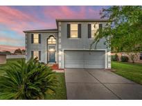 Charming two-story home with a well-maintained lawn and two car garage at sunset at 181 Zachary Wade St, Winter Garden, FL 34787