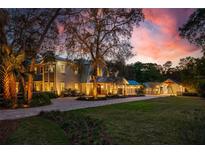 Stately home featuring a beautiful brick driveway, lush landscaping, and stunning sunset views at 2240 W Dale Cir, Deland, FL 32720