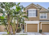 Inviting two-story townhome with a single-car garage and lush tropical landscaping at 2804 Polvadero Ln # 107, Orlando, FL 32835
