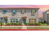 Charming townhome featuring a neatly landscaped front yard and a well-maintained exterior with updated windows at 3127 Via Otero Dr, Kissimmee, FL 34744