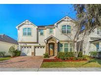 Charming two-story home with a brick driveway, two-car garage and manicured landscaping at 5029 Southlawn Ave, Orlando, FL 32811