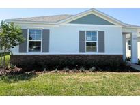 Charming single-story home featuring gray shutters, a stone facade, and a well-manicured lawn at 5203 Marshelder St, Apopka, FL 32712