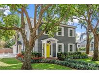 Charming two-story home featuring a vibrant yellow front door and manicured landscaping at 1701 Delaney Ave, Orlando, FL 32806