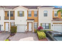 Inviting townhome with a well-manicured lawn, neutral colors, and a one-car garage on a brick paved driveway at 3466 Allegra Cir, St Cloud, FL 34772