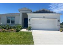 Charming single-Gathering home featuring a 2-car garage, manicured lawn, and a vibrant blue front door at 4086 Gooseberry Trl, Kissimmee, FL 34746