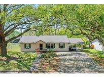 Charming single-story home with a cozy carport and a well-maintained front yard with mature trees at 412 N Boyd St, Winter Garden, FL 34787