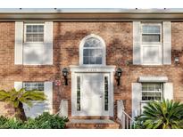 Charming brick home featuring a bright white door with decorative windows and sidelights at 4200 Lake Underhill Rd # 2B1, Orlando, FL 32803