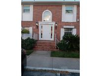 Inviting brick condo with a white front door, sidelights, arched window, and decorative shutters offers classic charm at 4200 Lake Underhill Rd # 2B1, Orlando, FL 32803