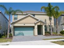 Two-story home featuring a two-car garage, with a charming entryway, and complemented by lush palm trees at 4489 Monado Dr, Kissimmee, FL 34746