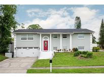 Charming two-story home with a red front door, white columns and a well-manicured lawn at 504 Teakwood Dr, Altamonte Springs, FL 32714
