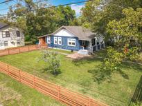 Charming home features a spacious lawn, painted blue exterior, and cozy front porch at 505 E Plymouth Ave, Deland, FL 32724