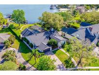 Breathtaking aerial view of lakeside home with lush landscaping, pool, and a private boat dock at 5101 The Oaks Cir, Orlando, FL 32809