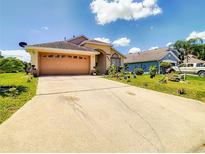 The exterior of this home features a two car garage, nice landscaping, and a long driveway at 527 Durango Loop St, Davenport, FL 33897