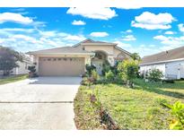 Inviting single-story home featuring a well-manicured lawn, attached garage, and beautiful landscaping at 527 Durango Loop St, Davenport, FL 33897