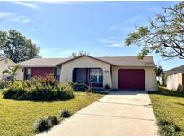 Charming single-story home with a red garage door and well-maintained lawn at 716 Caribou Dr, Kissimmee, FL 34759