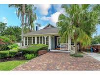 Charming home with a brick driveway, front porch, and lush tropical landscaping at 719 S Summerlin Ave, Orlando, FL 32801