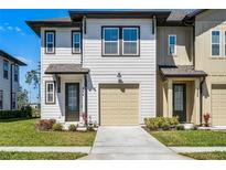 Charming townhome with a one-car garage, neat landscaping and inviting front entrance at 824 Longboat Dr, Davenport, FL 33896