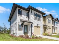 Charming two-story home with white siding, a single-car garage, and a neatly landscaped front yard at 824 Longboat Dr, Davenport, FL 33896