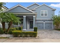 Charming two-story home with manicured landscaping, covered porch, and two-car garage at 10509 Authors Way, Orlando, FL 32832