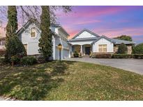 Charming home with a well manicured lawn, a stone accent, and three car garage under a vibrant sky at 1403 Lake Whitney Dr, Windermere, FL 34786