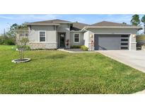 Charming single-story home featuring a well-manicured lawn, stone accents, and a modern gray garage door at 19301 Wembley Ave, Orlando, FL 32833