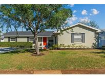 Charming single-story home featuring a bright red front door and lush green lawn at 230 S Ranger Blvd, Winter Park, FL 32792