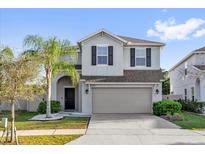 Charming two-story home featuring a well-manicured lawn, palm tree, and a two car garage at 3179 Turret Dr, Kissimmee, FL 34743