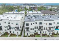 Modern townhomes with white exteriors and wrought iron balconies in a desirable urban neighborhood at 62 W Jersey St # 13, Orlando, FL 32806