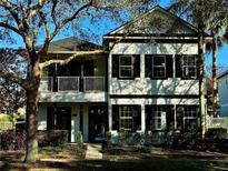 Charming two-story home featuring classic black shutters and a cozy second-story balcony at 7548 Gathering Dr, Reunion, FL 34747