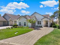 Beautiful single-story home with stone accents, paver driveway, lush lawn, and well-maintained landscaping at 10148 Chiltern Garden Dr, Orlando, FL 32827