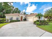 Spacious home with a large driveway, attached garage, and lush tropical landscaping at 1679 Shadowmoss Cir, Lake Mary, FL 32746