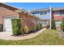 Charming townhouse with brick facade, lush landscaping, and a well-maintained front yard at 17 Lawn St, Oviedo, FL 32765