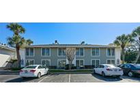 Two-story condo building showing parking lot with reserved parking spaces and manicured landscaping at 1935 Conway Rd # R5, Orlando, FL 32812