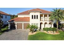 Stunning two-story home with a red tile roof, lush landscaping, and a paver driveway at 3687 Farm Bell Pl, Lake Mary, FL 32746