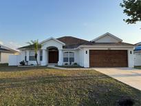Charming single-story home with a well-manicured lawn and a cozy, inviting entrance at 403 Britten Dr, Kissimmee, FL 34758
