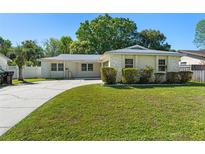 Charming single-story home with a well-maintained lawn, lush landscaping, and a concrete driveway at 7600 Boreas Dr, Orlando, FL 32822